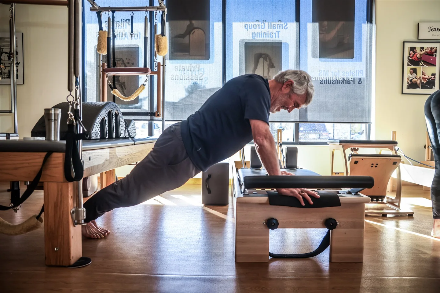 A client practices a supported plank on a Pilates chair at Lakewood